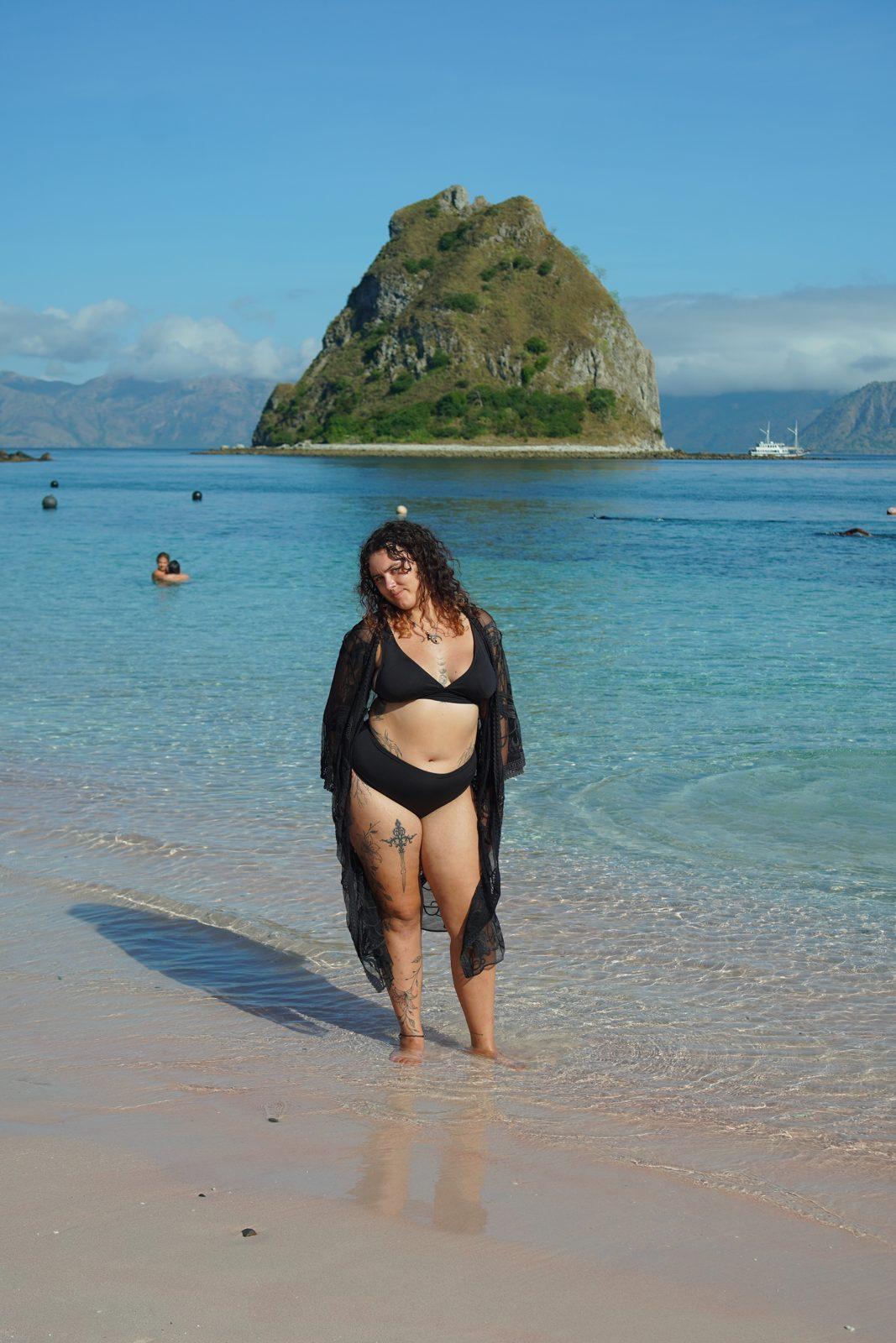 Kelor – woman walking in shallows, islet behind (Real photo from a Komodo Explorer trip)