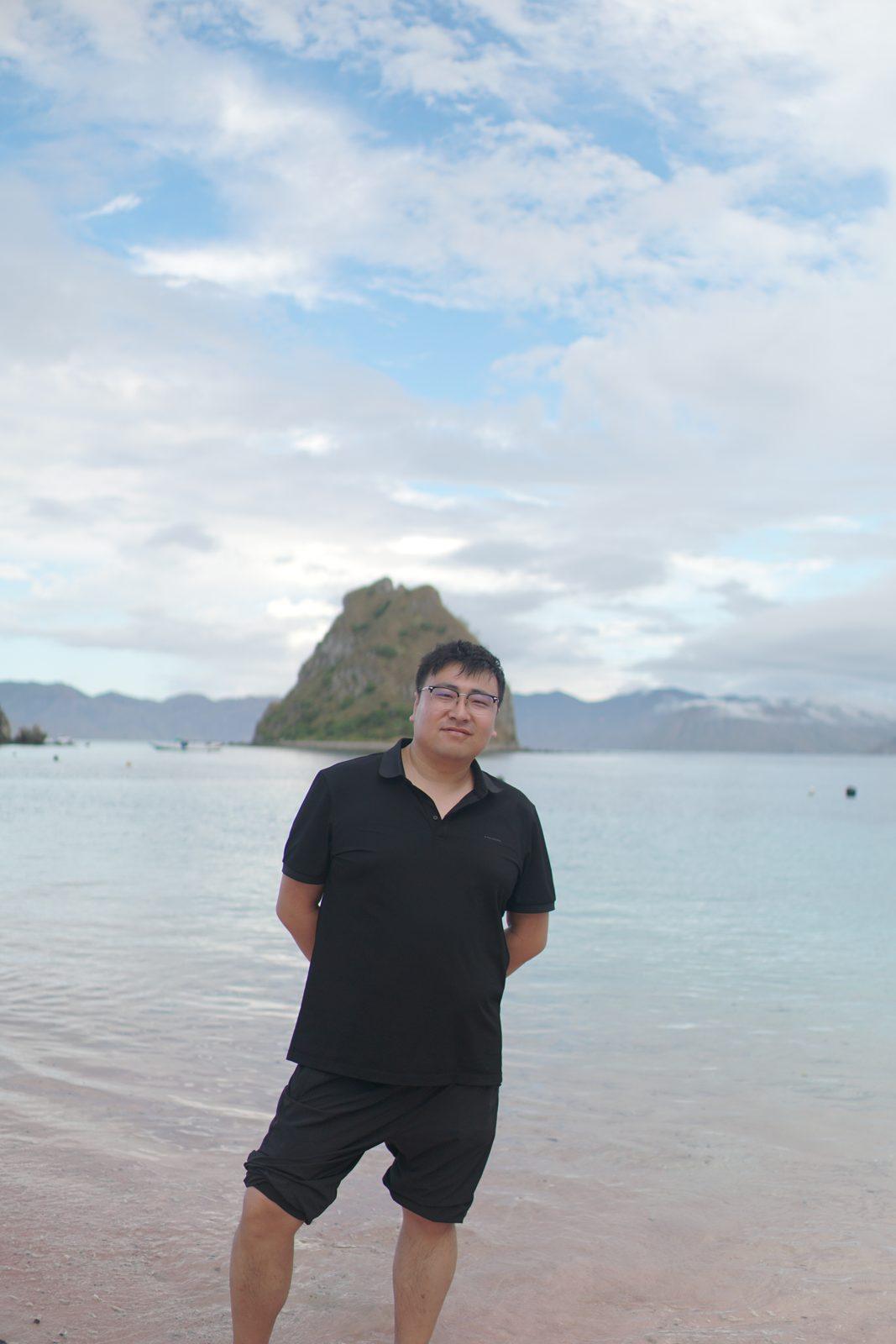 Kelor – man standing in shallows, islet behind (Real photo from a Komodo Explorer trip)