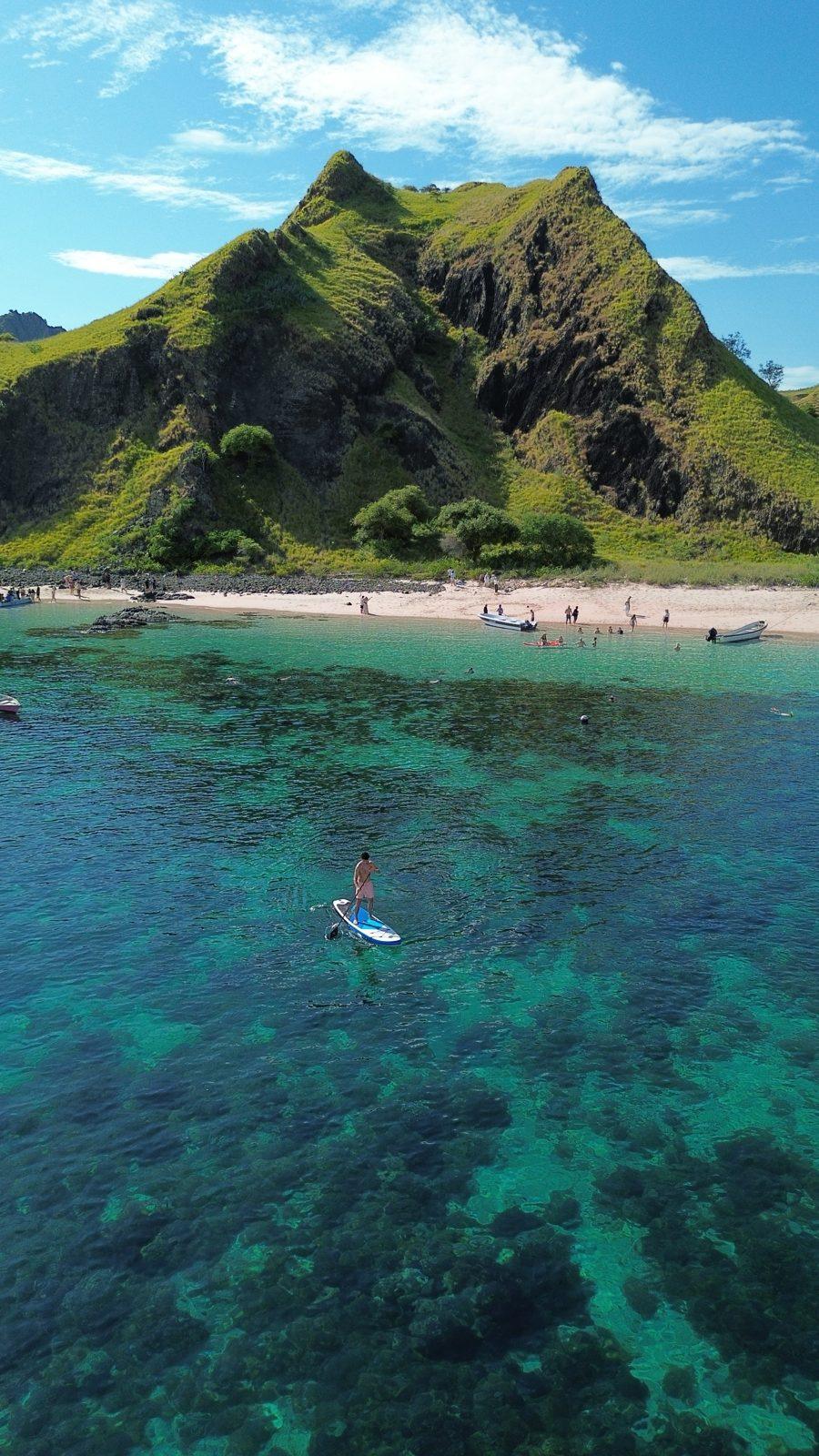Kelor – paddleboarder off steep green hill island (Real photo from a Komodo Explorer trip)
