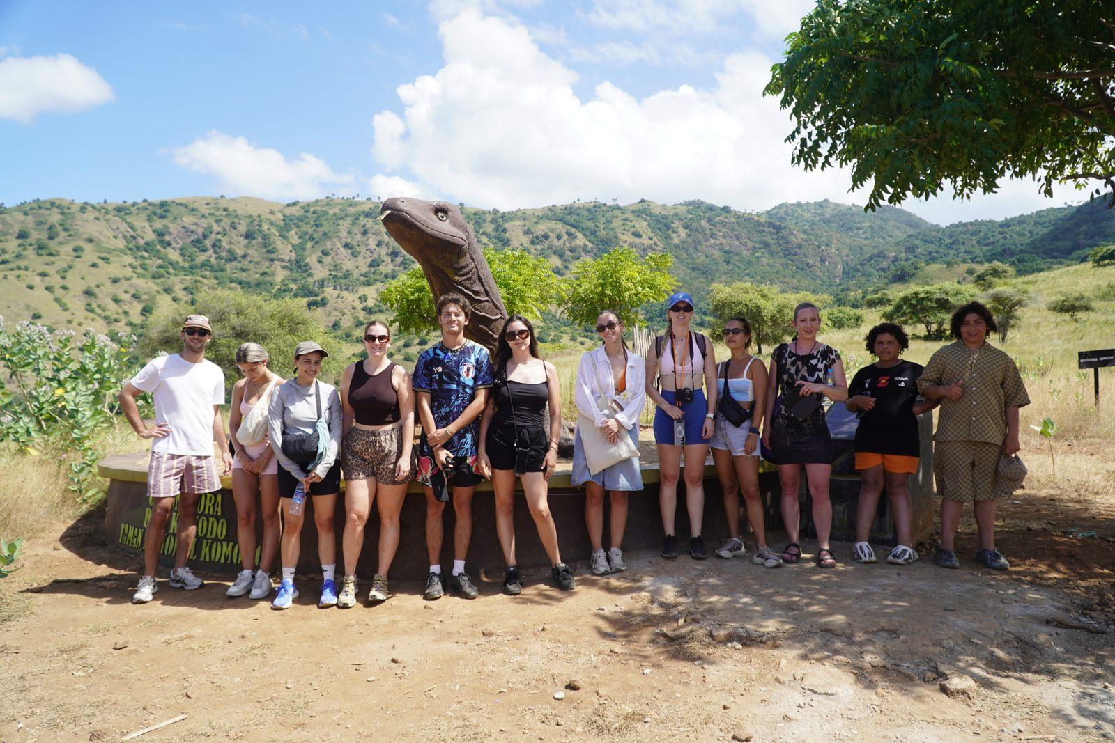 Komodo – group posing on savanna with dragon (Real photo from a Komodo Explorer trip)