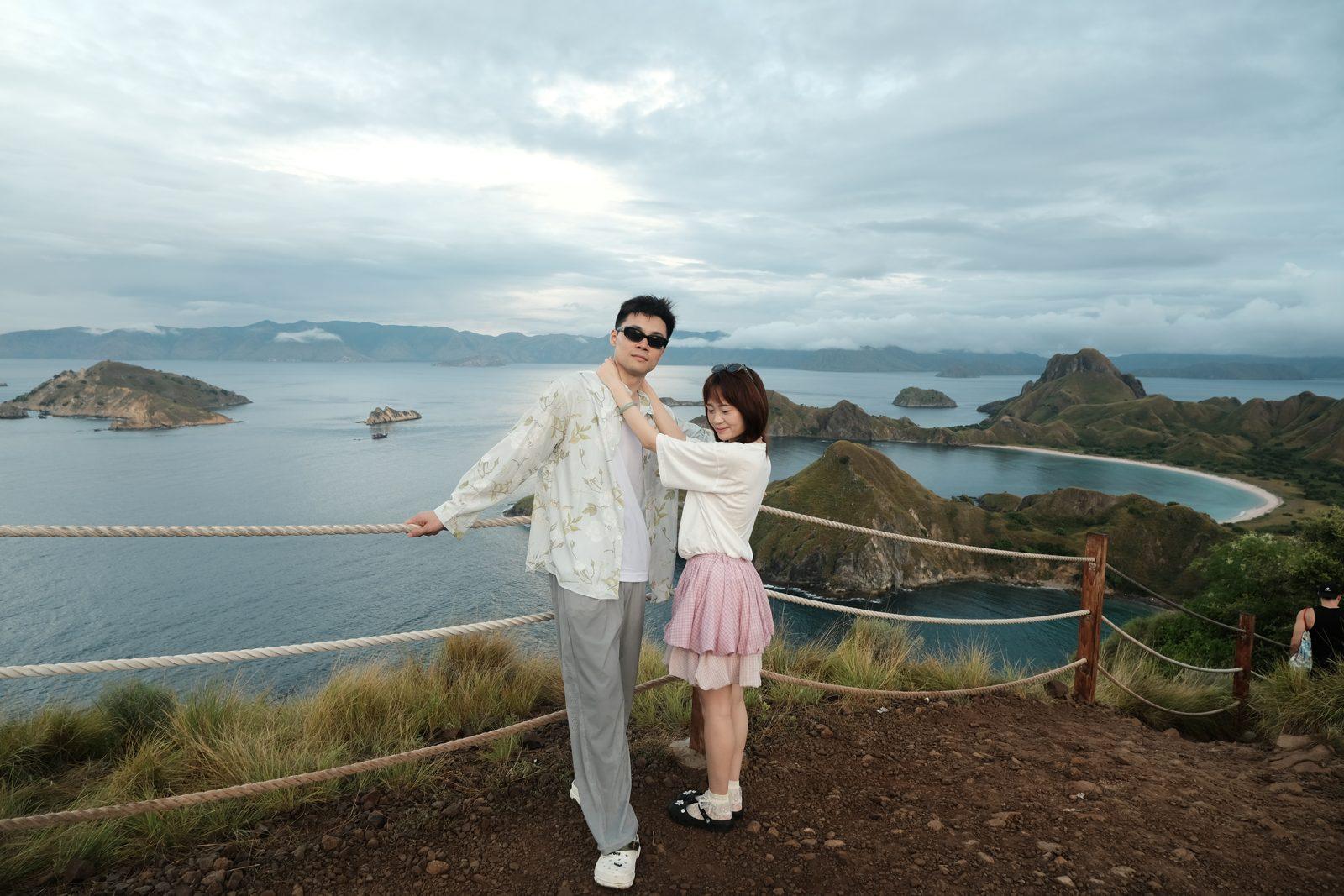 Padar – Couple posing at rail, wide Padar bays (Real photo from a Komodo Explorer trip)