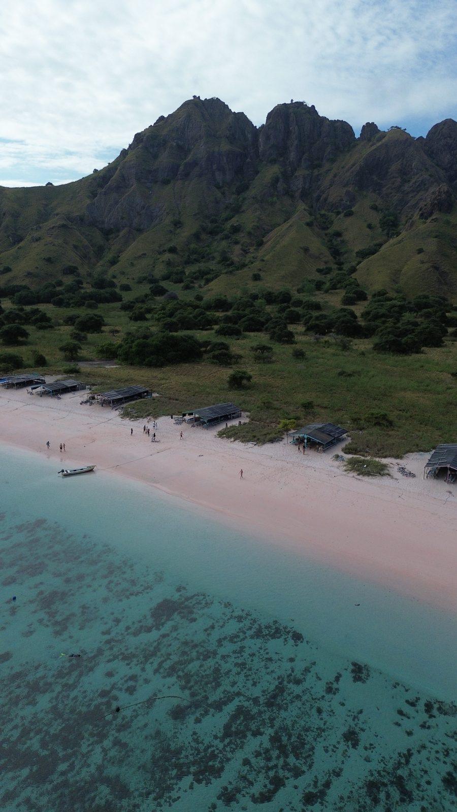 Pink Beach – Aerial pink beach below jagged green ridge (Real photo from a Komodo Explorer trip)