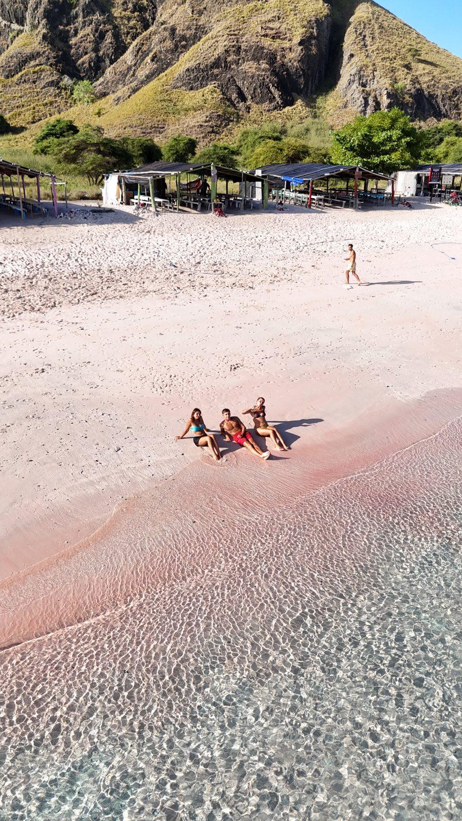 Pink Beach – group lying on pink sand, hill left (Real photo from a Komodo Explorer trip)